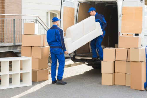 Professional movers handling packed household items during a Swisscottage relocation