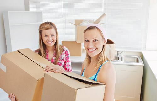 Movers securing a piano for safe transport through a narrow hallway